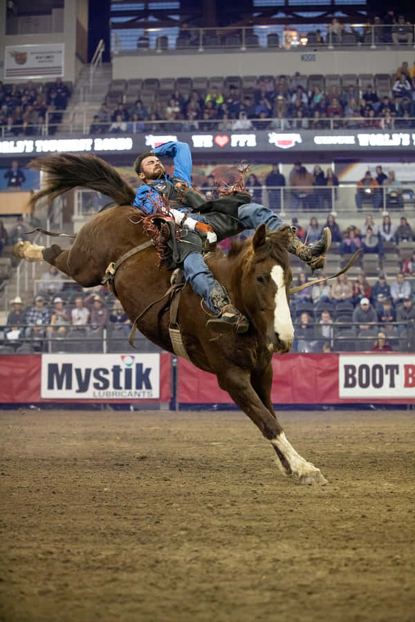 En cowboy der viser sine rodeofærdigheder på en hest.