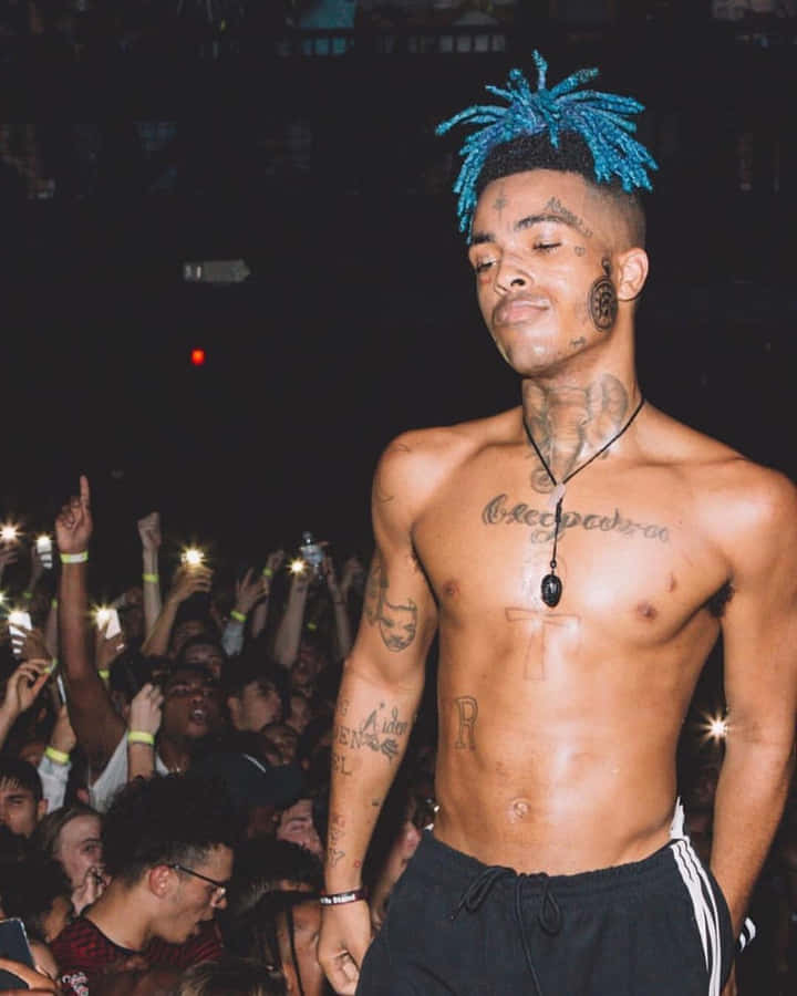 XXXTentacionsfoggia i capelli blu in questo nuovo look audace e accattivante.