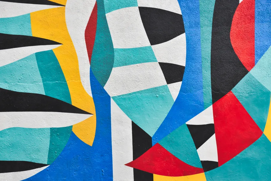 Abstract colorful art with different shapes and sizes painted on wall.