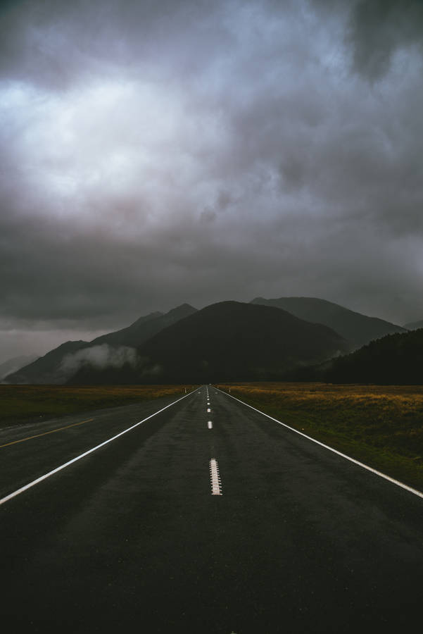 Download Gray Road Under Cloudy Sky Wallpaper | Wallpapers.com