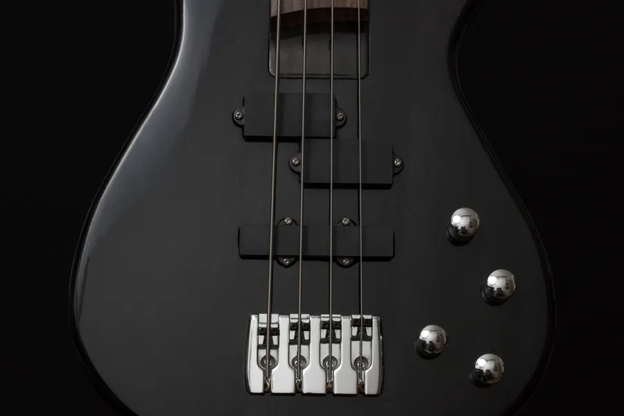 Bass guitar with silver controls pure black wallpaper.