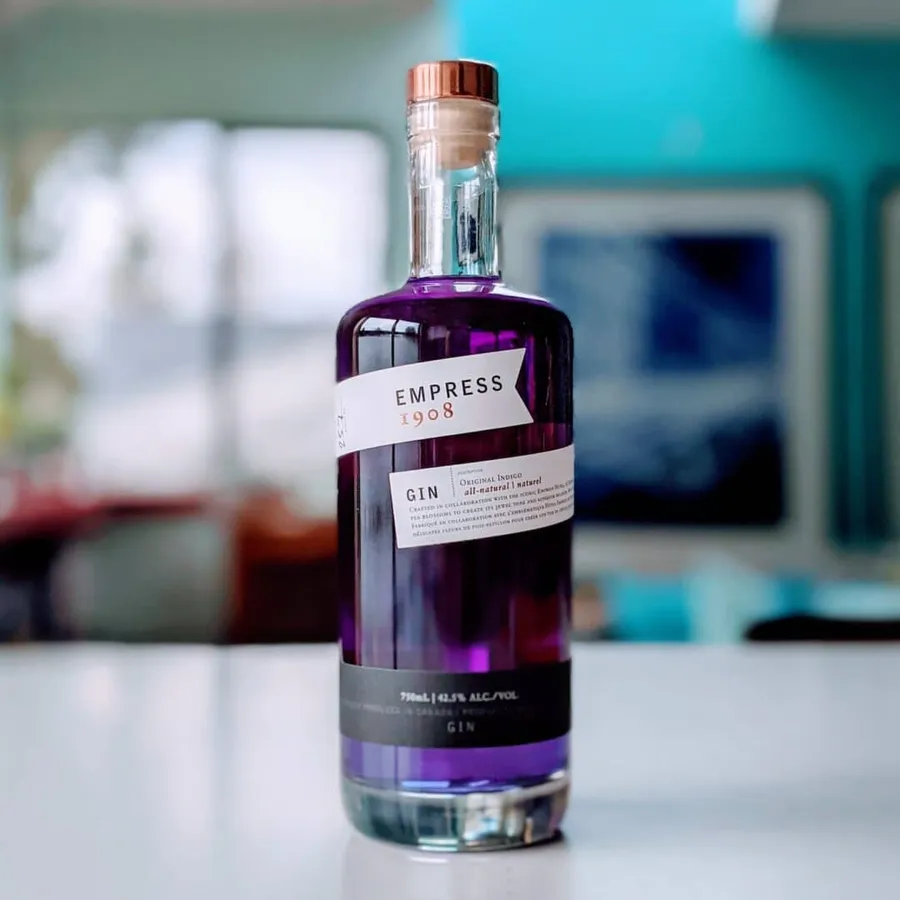 A bottle of Empress 1908 Gin presented on a sleek, modern table.
