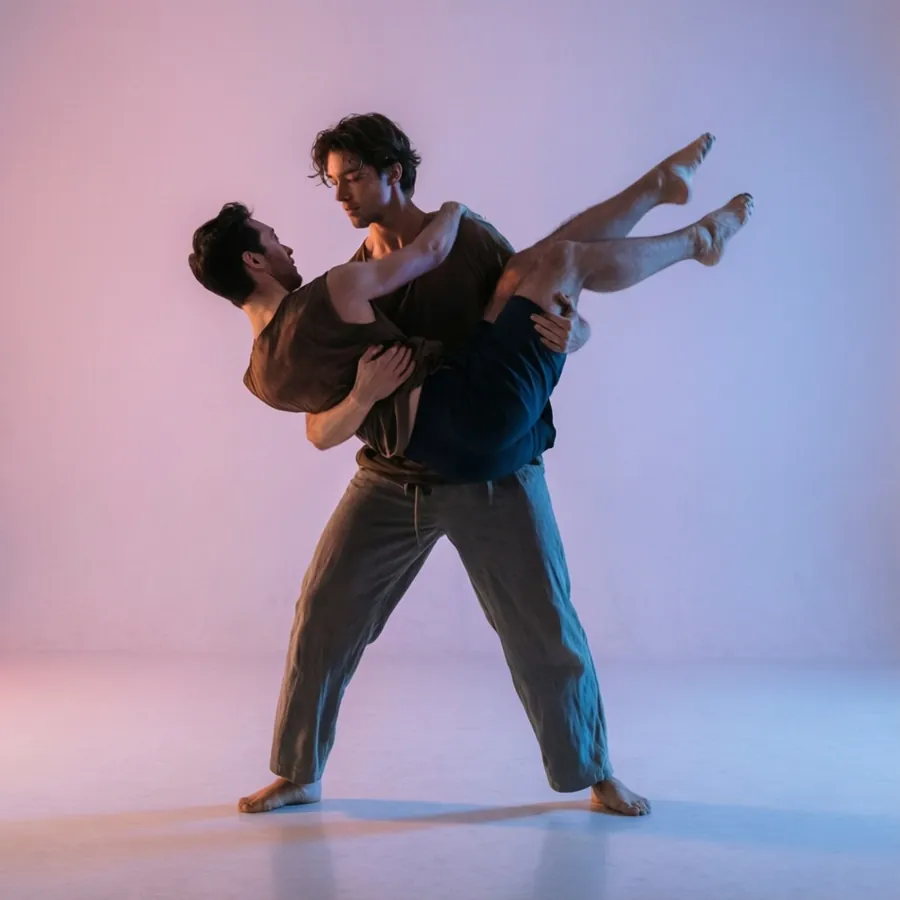 A modern dance duet with a lift, soft pastel lighting.