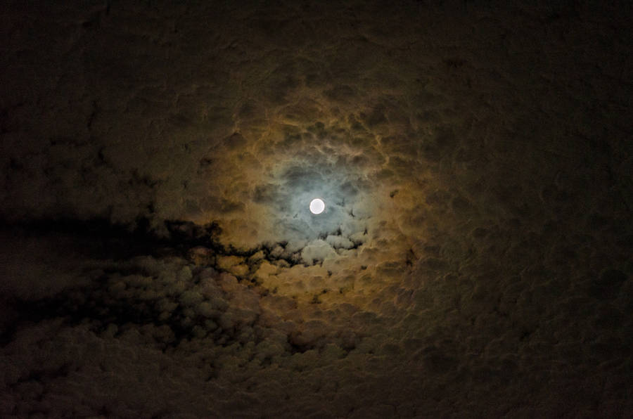 Bright Moon surrounded by clouds. Magical view of nature. Full moon evening.