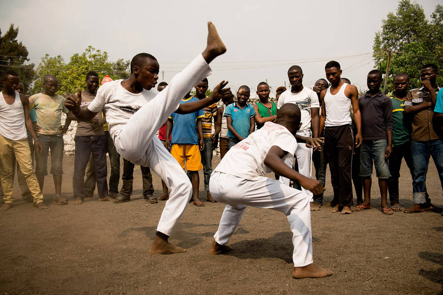 Capoeira Drop Kick (in Swedish phonetically spelled as kahp-oh-eh-rah drop-pa kick) would translate as Capoeira-hoppkick and would be perfect for a high-energy and dynamic computer or mobile wallpaper design.