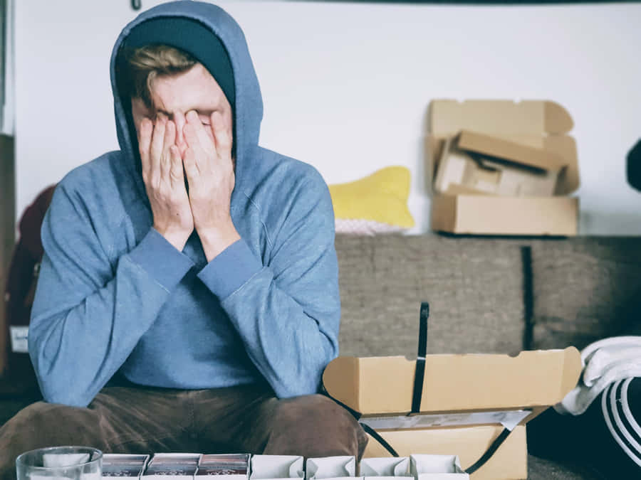 ÜberforderterMann in einem Kapuzenpulli
