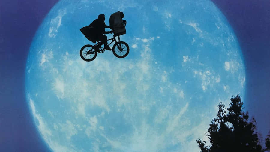 unuomo che guida una bicicletta di fronte a una luna piena