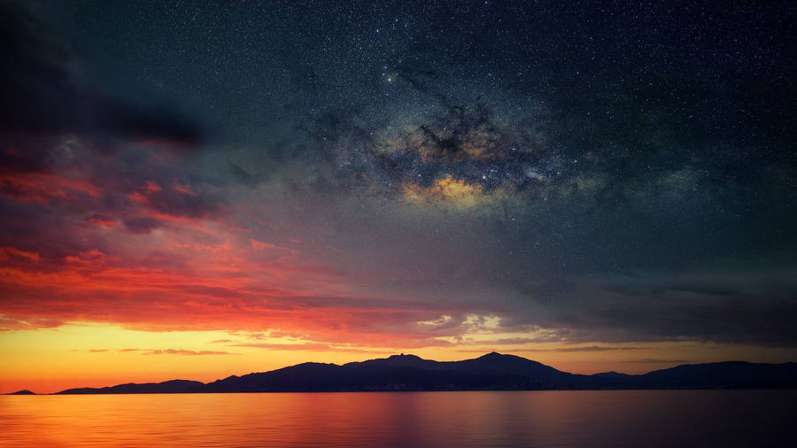 Ocean under combination sky with sunset and galaxy wallpaper
