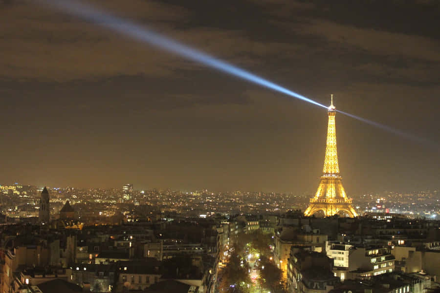 Eiffeltårnetglimter i natskæret over Paris på computer eller mobil tapet.