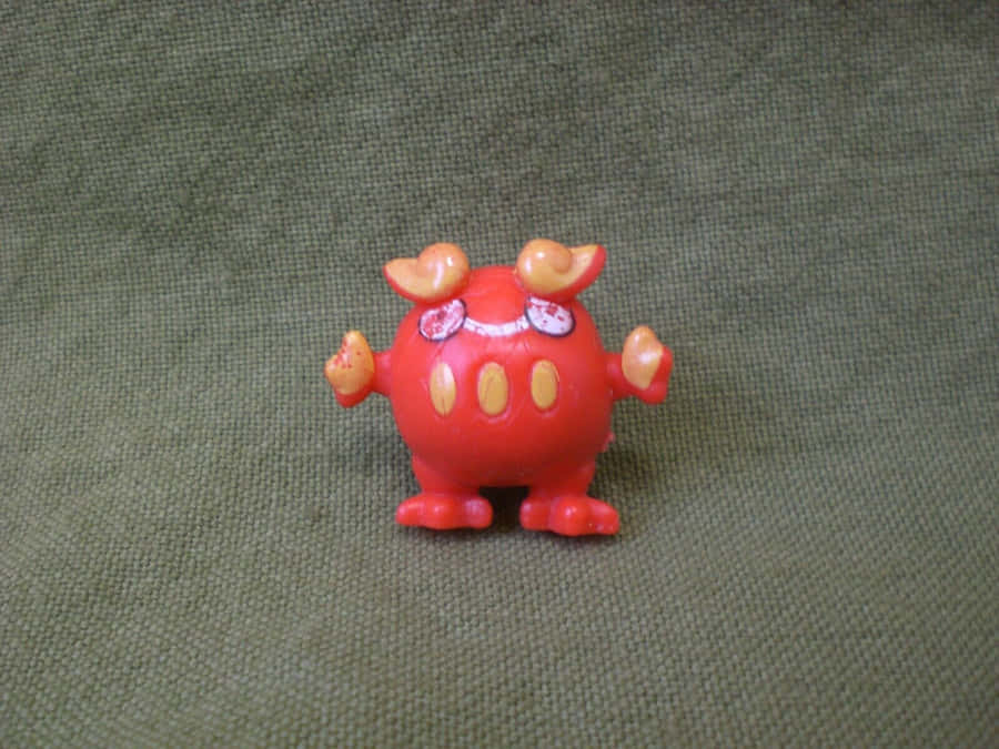 Rote Darumaka Figur auf strukturiertem Hintergrund