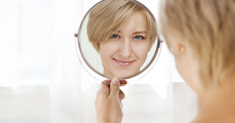 Reflektionav en fåfäng blond kvinna