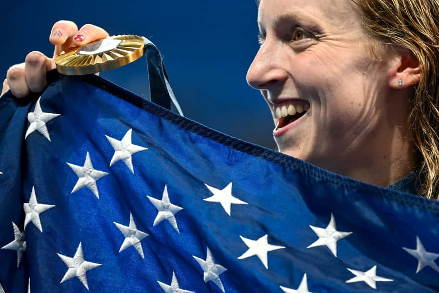 Olympische Schwimmerin feiert mit Goldmedaille und amerikanischer Flagge