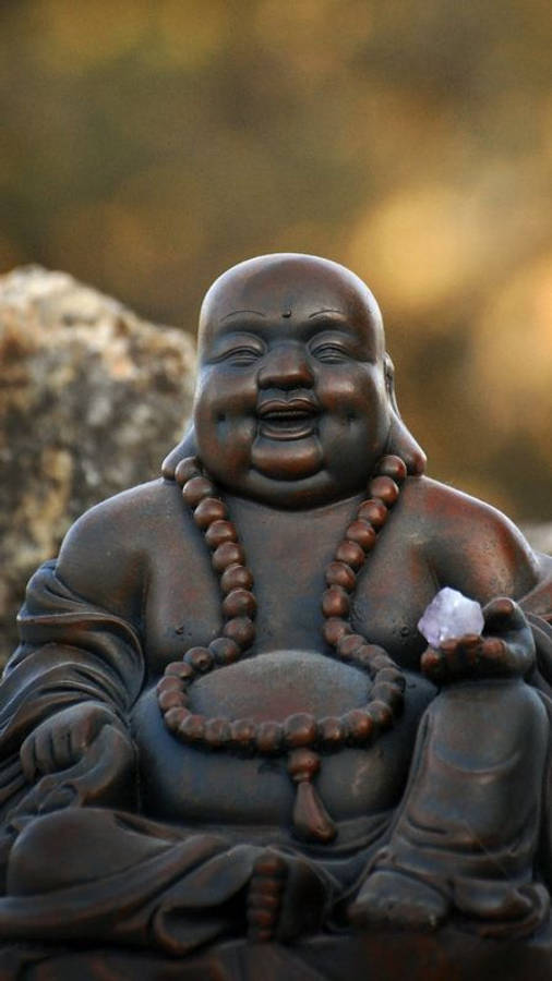 LachendeBuddha Statue, die einen weißen Kristall hält