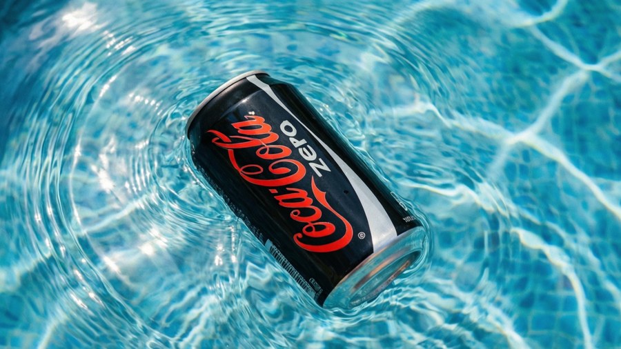 Summer wallpaper with a Coke Zero can in clear blue water with ripples.