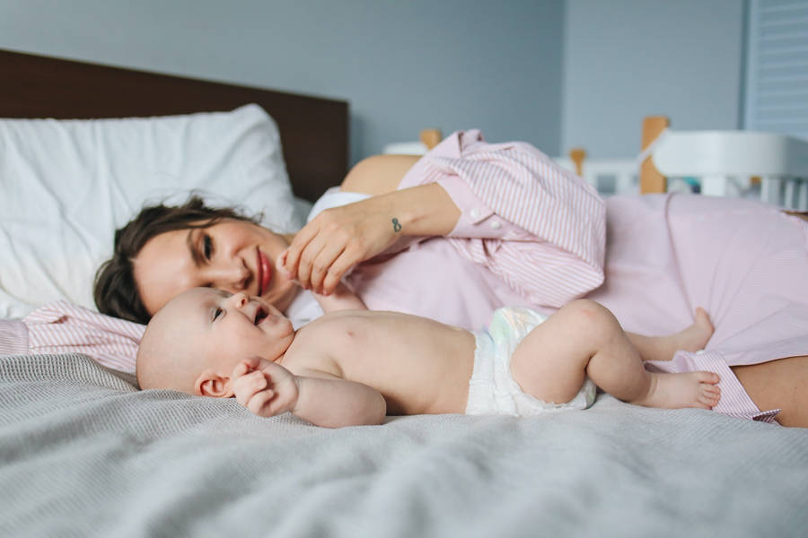 Mutterliegt im Bett mit Baby Liebe