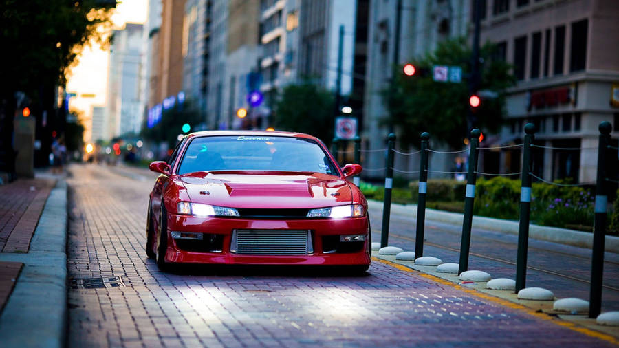 Red Nissan Silvia S14 car at paved city side street wallpaper