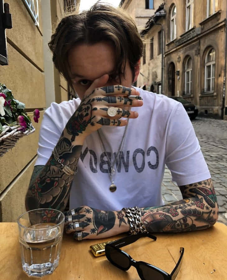 Ungmand viser sin lyse og livlige tatovering frem.