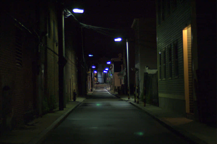 Becoescuro com background de luzes de rua azuis.