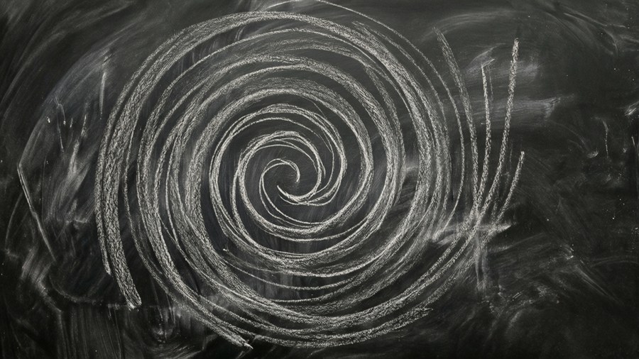 Blackboard with illegible chalk spiral pattern, smudges, creative.