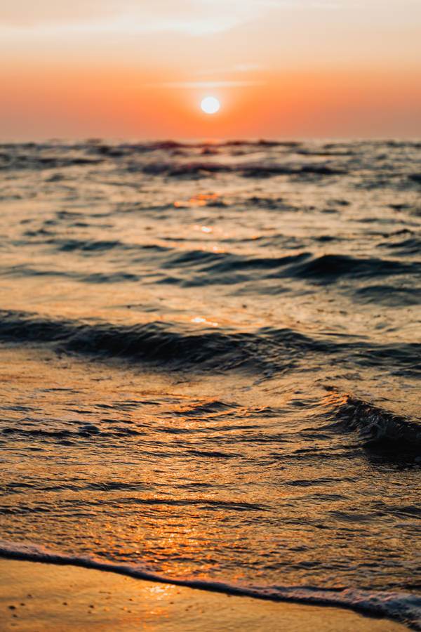 Download Sunset Over Beach Wave Iphone Wallpaper | Wallpapers.com