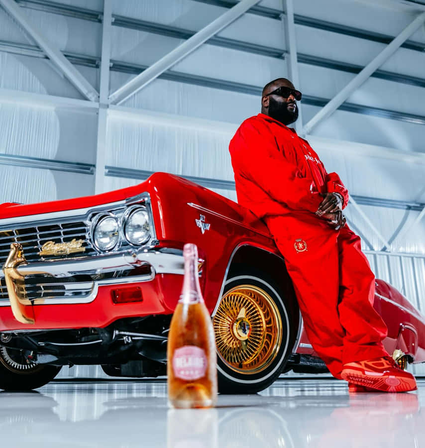 Rick Ross em Traje Vermelho com Carro Clássico