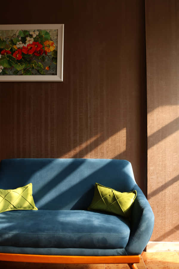 Blå sofa med to grønne puder sovesofa træ baggrund