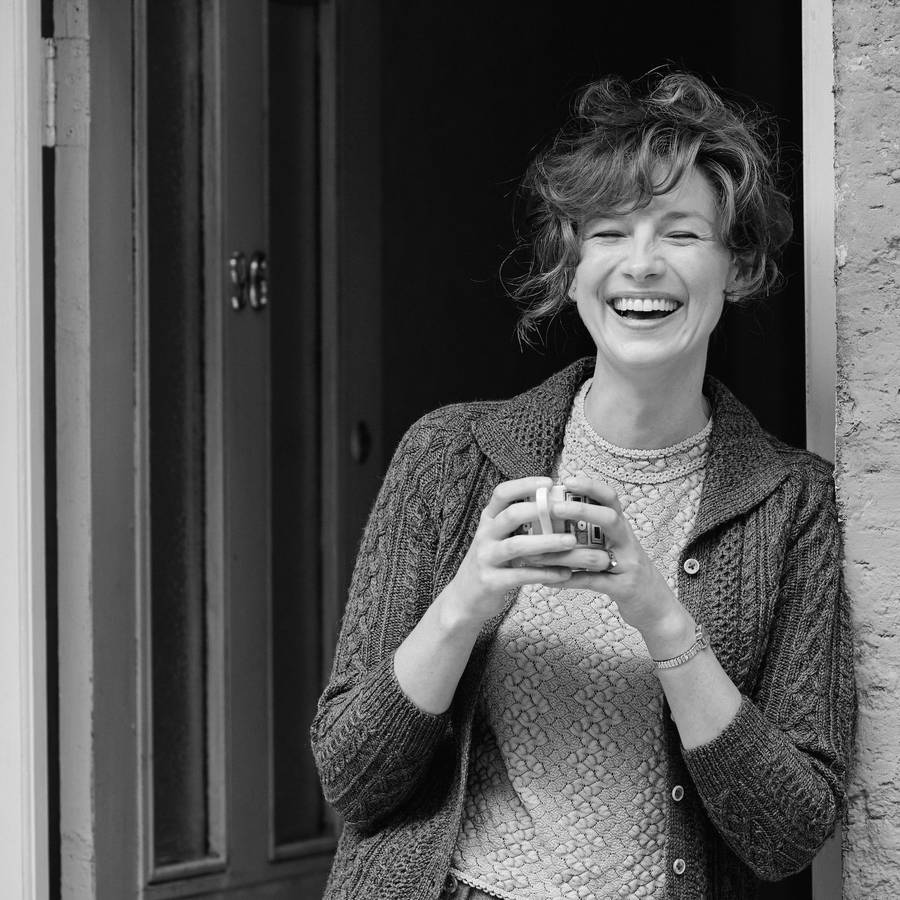 EineFrau hält eine Tasse Kaffee in der Hand.