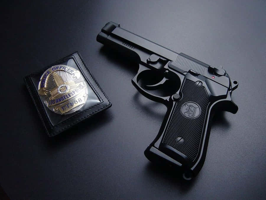 Distintivo de Polícia e Arma na Mesa
