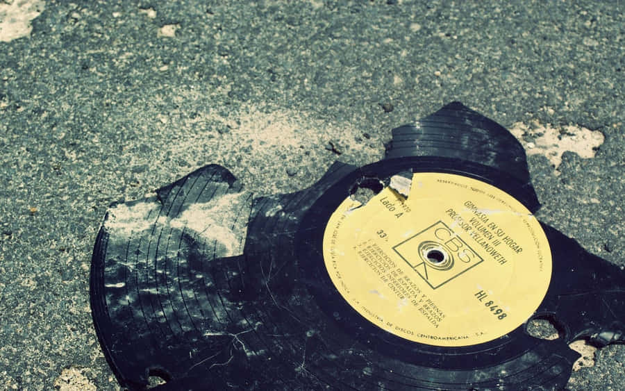 Zerbrochene Vinyl-Schallplatte auf dem Gehweg