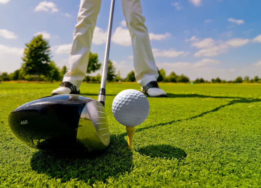 Umhomem está segurando um taco de golfe e uma bola