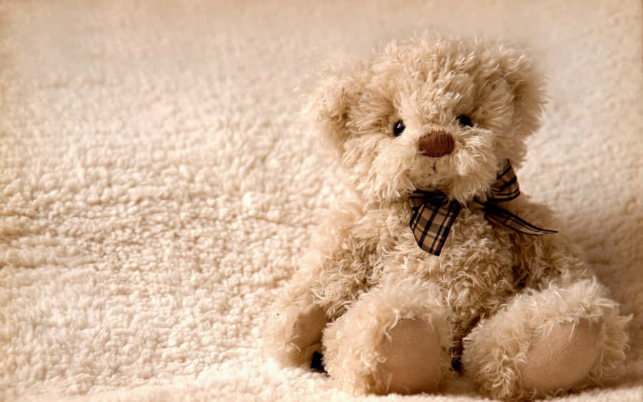 EinTeddybär sitzt auf einer Decke.