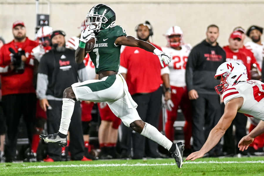 Jogador de Futebol do Michigan State Pegando a Bola