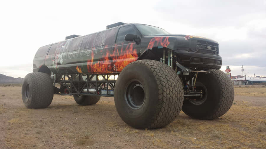 Imagemde um longo caminhão monstro preto.