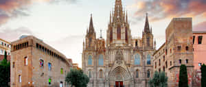 Gothic cathedral with spires at sunset surrounded by historic stone buildings and trees. — 2560X1080 Picture