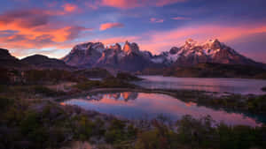 Verschneite Gipfel spiegeln sich in einem ruhigen See bei Sonnenuntergang mit rosa und violetten Himmeln. — 1080p HD Wallpaper