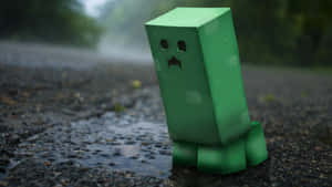 Green blocky creeper standing in rain puddle on asphalt road.