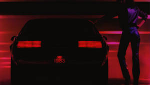Persona in piedi accanto a una Porsche del 1983 con fanali posteriori rossi luminosi in luce rossa neon. — Old Times Immagine