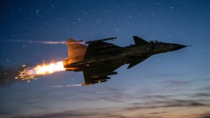 Gripen dengan jejak knalpot afterburner saat senja dengan bintang.