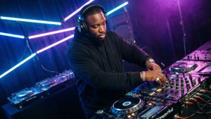 Andre Harris med hovedtelefoner og DJ-udstyr i et neonlyst studie