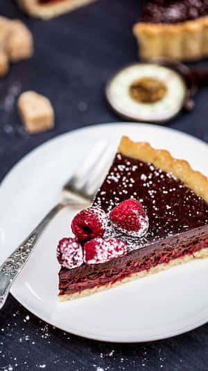 Bit choklad-hallonpaj med florsocker på vit tallrik med gaffel. — Desserter bilder Bakgrundsbilder