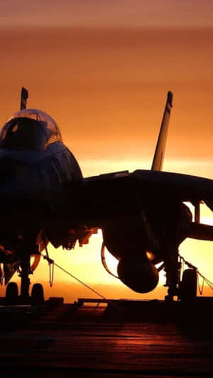 Fighter jet silhouette on aircraft carrier at sunset — Jet Wallpaper