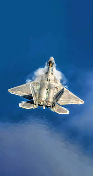 A fighter jet ascending into the blue sky with smoke trailing behind. — Military Plane Background