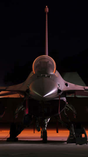 Um caça estacionado à noite com luzes laranja da pista brilhando sob ele. — Fundo de HD Jumbo Jets Fundos