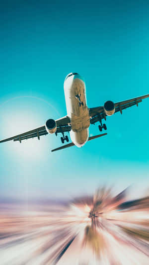 An airplane flying overhead with a sunburst and motion blur effect below.