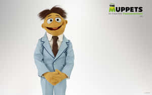 Muppet-Charakter in blauem Anzug und brauner Krawatte lächelt in die Kamera.