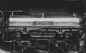 Close-up de um motor Bentley vintage com componentes mecânicos visíveis e marca. — Bentley Papéis de Parede