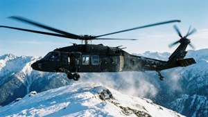 MH-60 Black Hawk melayang di atas punggung gunung bersalju di wallpaper musim dingin yang dingin