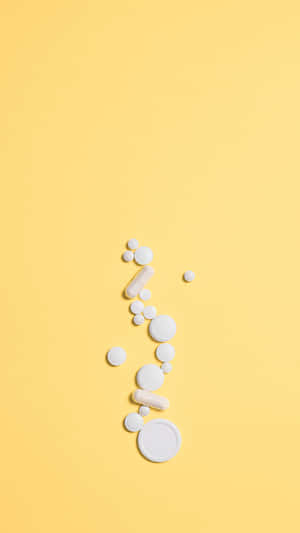 Vita piller och kapslar arrangerade diagonalt på en gul bakgrund. — Medicin Bilder