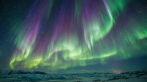 Bintang Biduk bersinar melalui aurora borealis di atas Arktik.