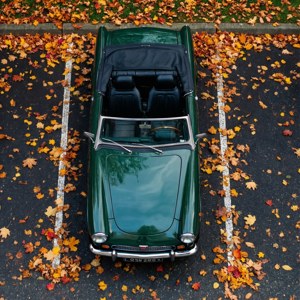 Top-down MG Midget zwischen Herbstblättern.